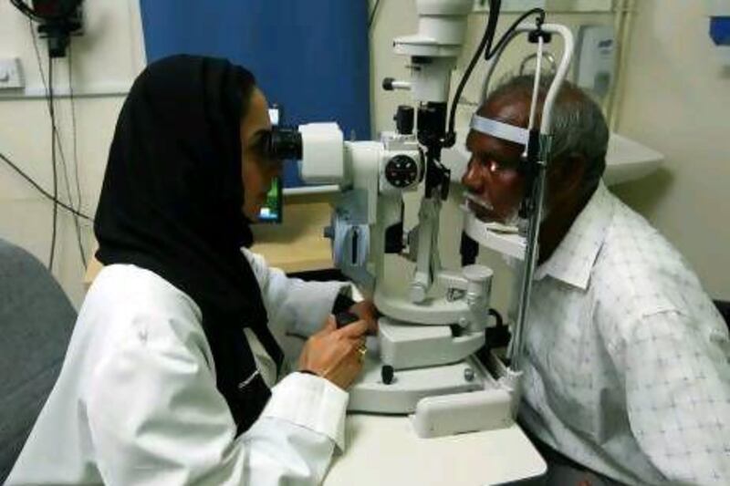 Dr Manal Taryam, an Emirati ophthalmology consultant with Dubai Health Authority, examines a patient at Rashid Hospital's outpatient clinic. Jeffrey E Biteng / The National