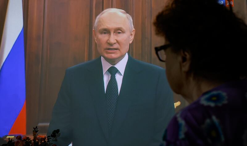 A woman watches Mr Putin's televised address to the nation,  in Moscow. EPA