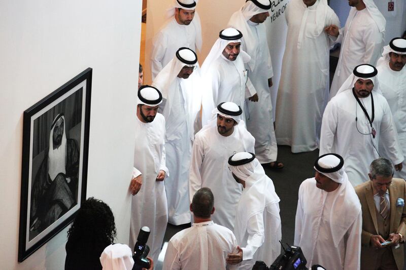 Dubai's crown prince, Sheikh Hamdan bin Mohammed Al Maktoum, center, looks at a picture of the late ruler of Abu Dhabi Sheikh Zayed bin Sultan Al Nahyan at Art Dubai in Dubai. Art Dubai is marking its 13th edition with an exhibition running March 20 through March 23. AP Photo