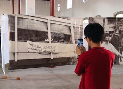 A visitor to an exhibition at the Secretariat building photographs an iconic image. Photo by Stephen Starr