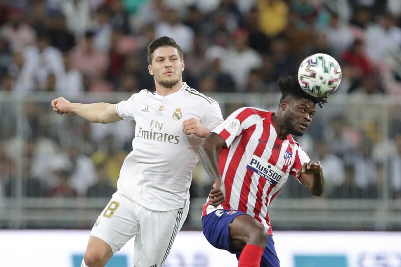 Real Madrid's Luka Jovic, left, fights for the ball with Atletico Madrid's Thomas Partey during the Spanish Super Cup Final soccer match between Real Madrid and Atletico Madrid at King Abdullah stadium in Jeddah, Saudi Arabia, Sunday, January12, 2020. AP Photo/Hassan Ammar