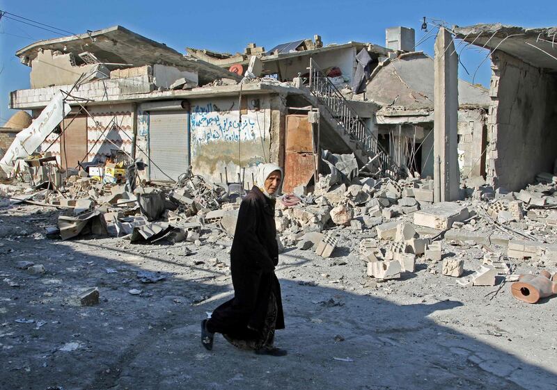 EDITORS NOTE: Graphic content / A Syrian woman walks past destruction at the site of a reported government bombardment in the village of Maasaran on the outskirts of Maaret al-Numan in Syria's northwestern Idlib province on December 17, 2019.  / AFP / Abdulaziz KETAZ
