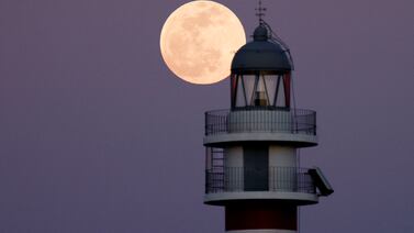 The Flower Moon rises behind the Arinaga lighthouse, on Gran Canaria in Spain, in 2022. Reuters