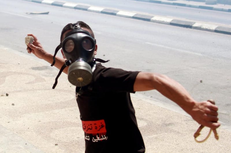 A Palestinian protester throws stones towards Israeli troops (unseen) during clashes near the main entrance of the West bank city of Bethlehem following a protest against Israel's military operation in the Gaza Strip. Musa Al Shaer / AFP

