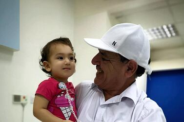 Taqwa Faisal Khan, one of the victims of the contamination, with her grandfather. Salam Al Amir / The National
