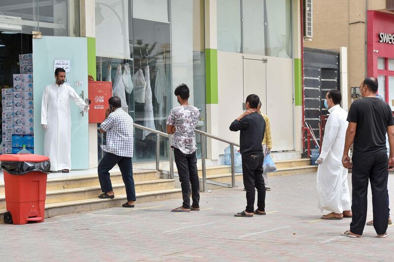 Customers queue outside a supermarket while maintaining social distancing during a nationwide curfew to stem the spread of Covid-19 in the Saudi capital Riyadh on April 13, 2020, ahead of the month of Ramadan. AFP