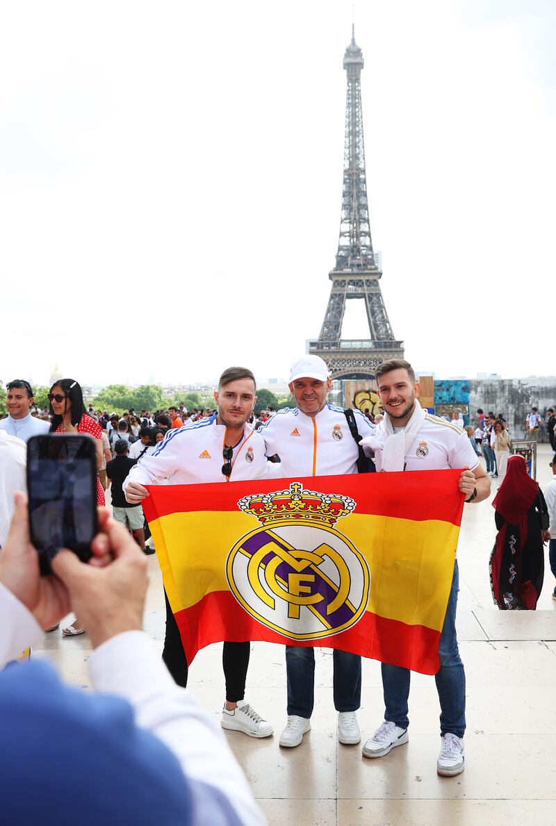  A group of Real Madrid fans pose for a photograph in front of the Eiffel Tower. Getty