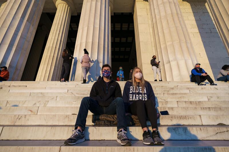 People gather on the steps of the Lincoln Memorial to watch the sunrise the day after incumbent President Donald Trump was defeated by his Democratic challenger, President-elect Joe Biden. AP