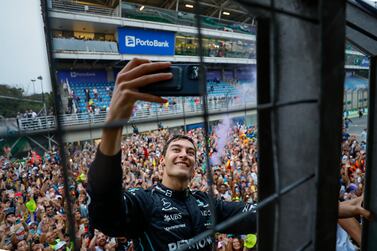 Mercedes driver George Russell, of Britain, takes a selfie with the crowd in the background after winning the Brazilian Formula One Grand Prix at the Interlagos race track in Sao Paulo, Brazil, Sunday, Nov. 13, 2022.  (AP Photo / Marcelo Chello)