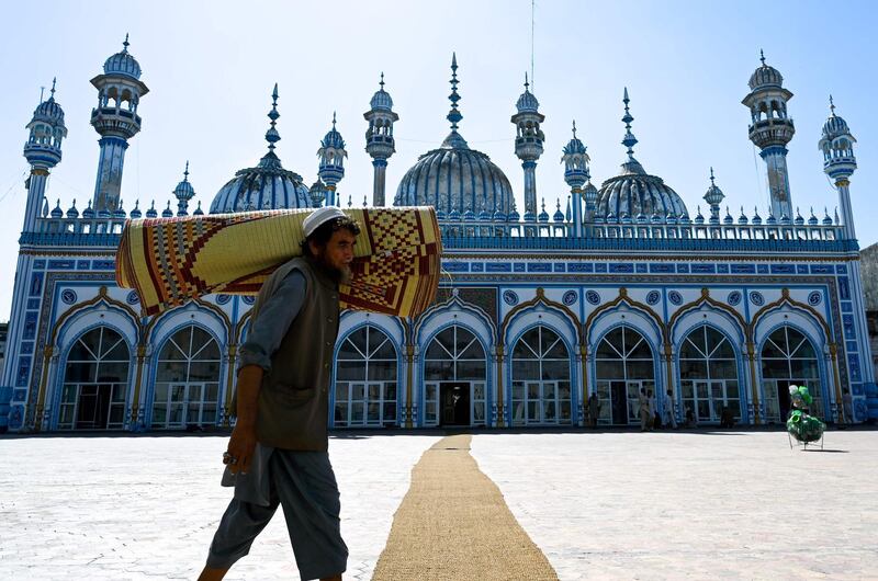 A Pakistani Muslim carries a prayer mat rolled up on his shoulder in preparation for the night special prayers in Rawalpindi on May 6, 2019, ahead of the start of the holy fasting month of Ramadan.

  Muslims are preparing for Islam's holy month of Ramadan, which is calculated on the sighting of the new moon, and during which they fast from dawn until dusk. / AFP / AAMIR QURESHI
