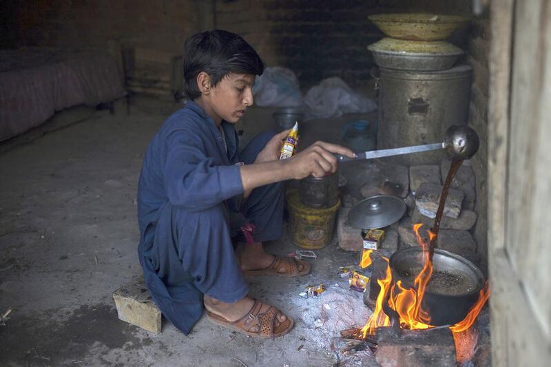 Samiullah, who says he is 14-years-old, prepares tea after finishing work at a coal mine in Choa Saidan Shah, Punjab. Nearly 60 per cent of Pakistan's working children are in Punjab province. Sara Farid / Reuters