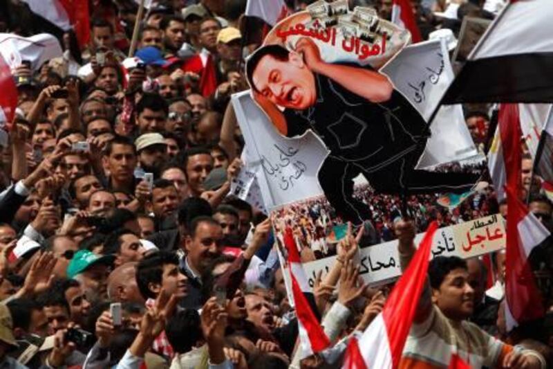 Protesters hold up a caricature of ousted president Hosni Mubarak carrying ''people's money'' in Tahrir Square, Cairo, April 8, 2011. Tens of thousands of Egyptians protested in Cairo on Friday demanding the prosecution of Hosni Mubarak and accusing the military of being too slow to root out corruption from his era.  REUTERS/Asmaa Waguih  (EGYPT - Tags: POLITICS CIVIL UNREST) *** Local Caption ***  CAI103_EGYPT-PROTES_0408_11.JPG