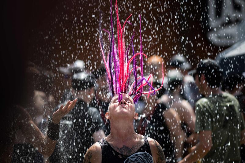 A person cools down with fresh water at the Hellfest metal music festival in Clisson, western France. AFP
