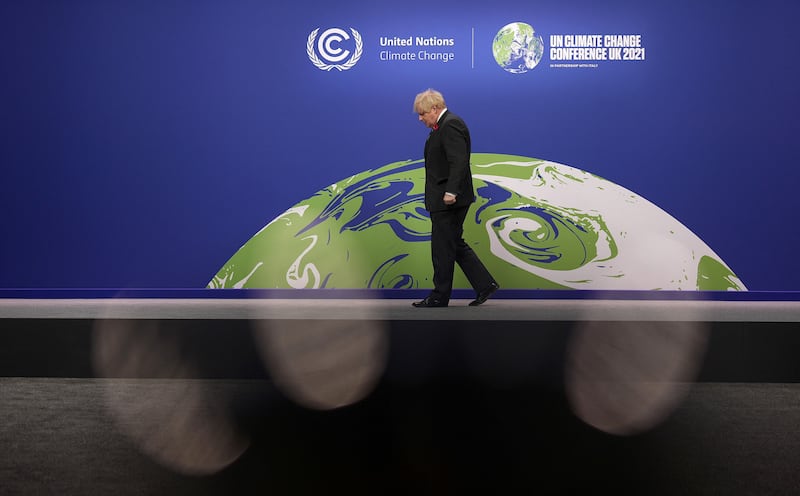 Boris Johnson waits to greet leaders as they arrive to attend. AFP