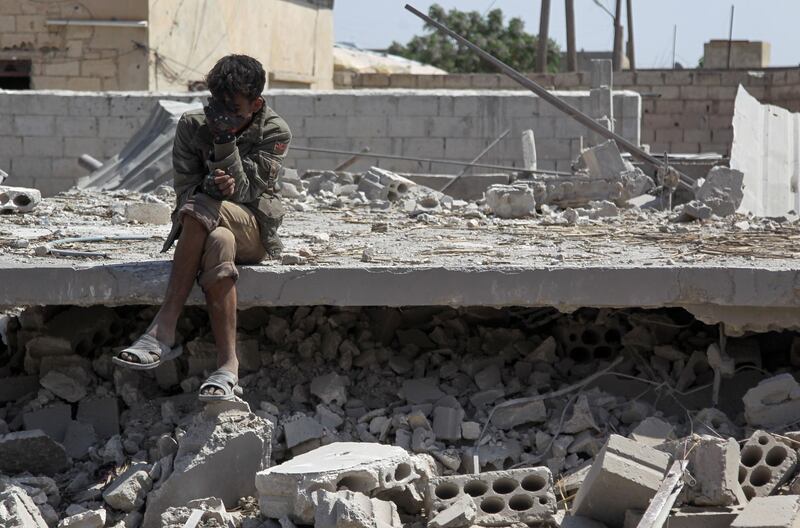TOPSHOT - A man sits amidst the rubble of a building, destroyed during airstrikes by the Syrian regime and their allies near the town of Saraqeb in Syria's rebel-held northwestern province of Idlib on May 7, 2019.  Air strikes and shelling killed 13 civilians in northwestern Syria today, a monitor said, in the latest escalation to rattle a months-old truce and spark displacement. / AFP / Amer ALHAMWE

