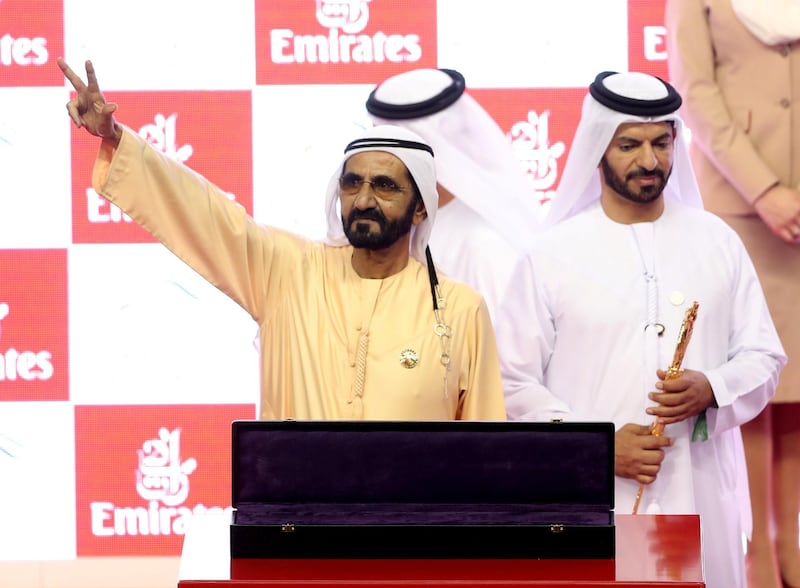 Sheikh Mohammed bin Rashid salutes the crowd before accepting the winning trophy at Dubai World Cup on Saturday. Ahmad Jadallah / Reuters