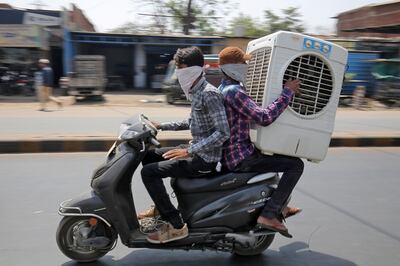 Men transport an air cooler on a two wheeler during a hot summer day in Ahmedabad, India May 24, 2018. REUTERS/Amit Dave - RC159A6B9280