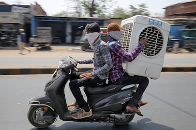 Men transport an air cooler on a two wheeler during a hot summer day in Ahmedabad, India May 24, 2018. REUTERS/Amit Dave - RC159A6B9280