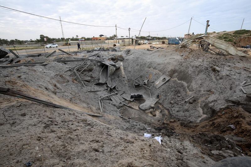 A Palestinian man walks past a crater on the ground following an Israeli air strike in Khan Younis. AFP