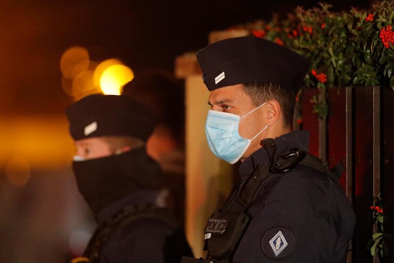 French police officers stand outside a high school after a history teacher who opened a discussion with students on caricatures of Islam's Prophet Muhammad was beheaded. AP