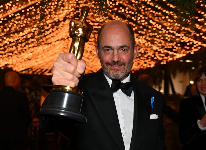 Edward Berger, winner of the Oscar for Best International Feature Film for All Quiet on the Western Front, sports a #WithRefugees blue ribbon. AFP