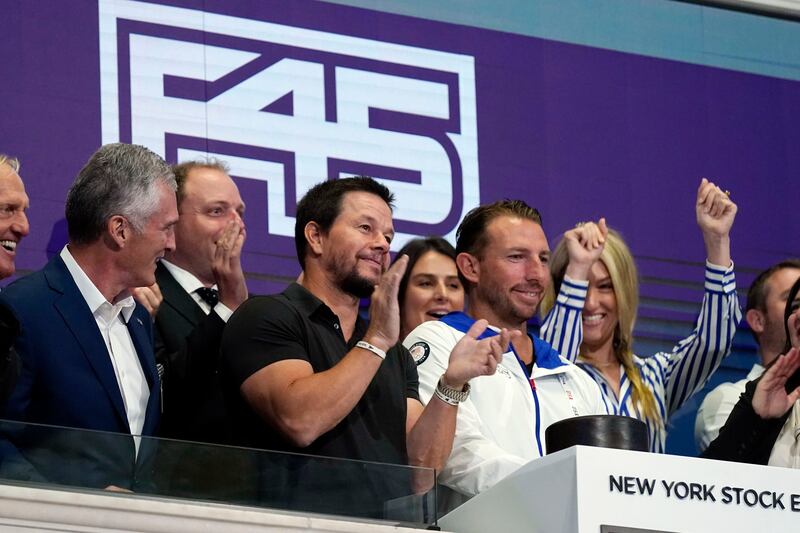 Actor Mark Wahlberg, second left, brand ambassador for fitness chain F45, applauds as company CEO and founder Adam Gilchrist, centre, rings the New York Stock Exchange opening bell, celebrating the company's IPO.  AP