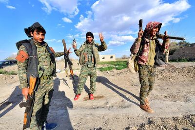 Fighters from the Syrian Democratic Forces (SDF) gesture the "V" for victory sign as they come back from the frontline in the Islamic State group's last remaining position in the village of Baghouz in the countryside of the eastern Syrian province of Deir Ezzor on March 19, 2019. - The Kurdish-led SDF have been closing in on IS fighters holed up in a small sliver of territory in the village of Baghouz in eastern Syria since January. (Photo by GIUSEPPE CACACE / AFP)