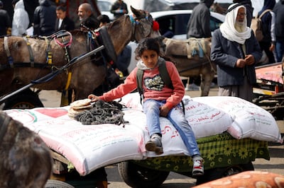 A girl sits on bags of flour distributed to Palestinians by UN staff, who have warned of famine in Gaza. Reuters