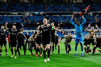 Ajax's players celebrate at the end of the UEFA Champions League round of 16 second leg football match between Real Madrid CF and Ajax at the Santiago Bernabeu stadium in Madrid on March 5, 2019. / AFP / GABRIEL BOUYS
