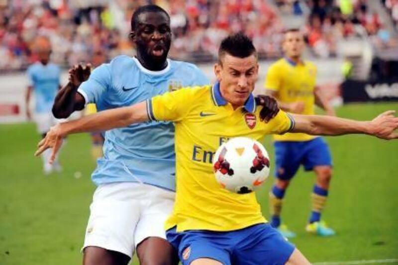 Manchester City's Yaya Toure, left, fights for the ball with Arsenal's Laurent Koscielny during a friendly match between Premier League teams Arsenal and Manchester City at the Helsinki Olympic Stadium in Helsinki, Finland on Saturday. Mikko Stig / AP Photo