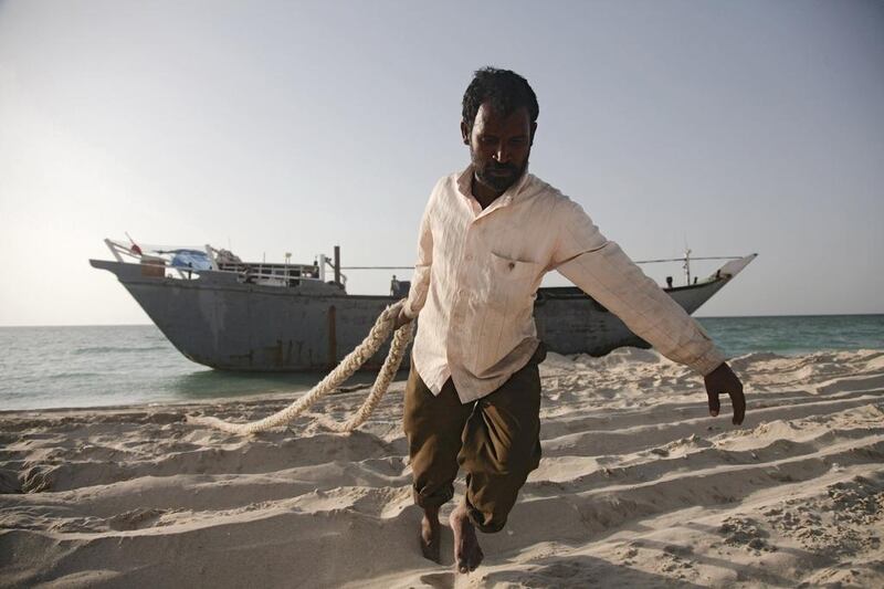 Seen here is Saidu, pulling rope that was cut off the boat onto a car. Lee Hoagland / The National

