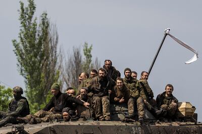 Ukrainian PoWs ride on top of an infantry fighting vehicle after a prisoner swap in the Donetsk region on Thursday. G7 leaders have pledged increased financial and humanitarian assistance for Ukraine in its conflict with Russia. Reuters 