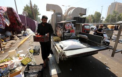 A supporter of Moqtada Al Sadr carries a box of tomatoes as they withdraw from the Green Zone in Baghdad. EPA 