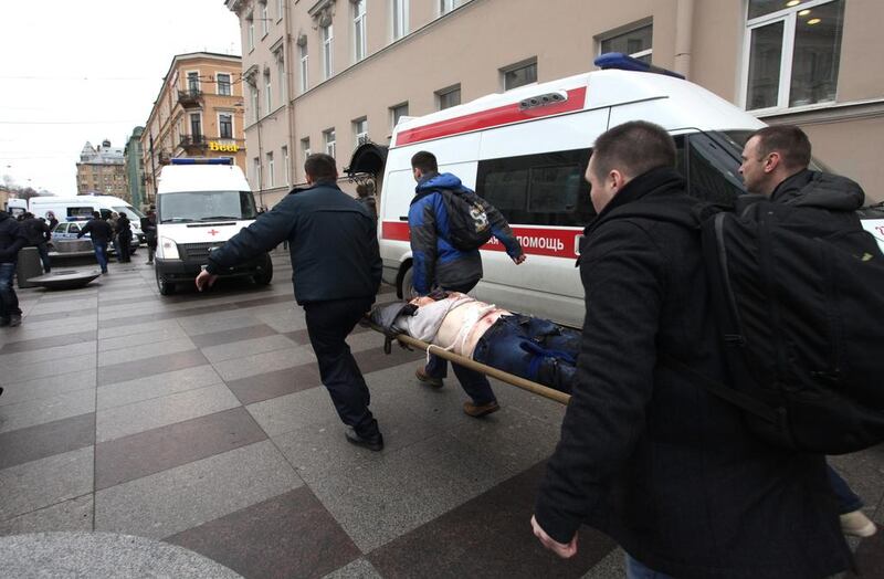 Men carry an injured person on a stretcher outside Technological Institute metro station in St Petersburg. Alexander Tarasenkov / AFP