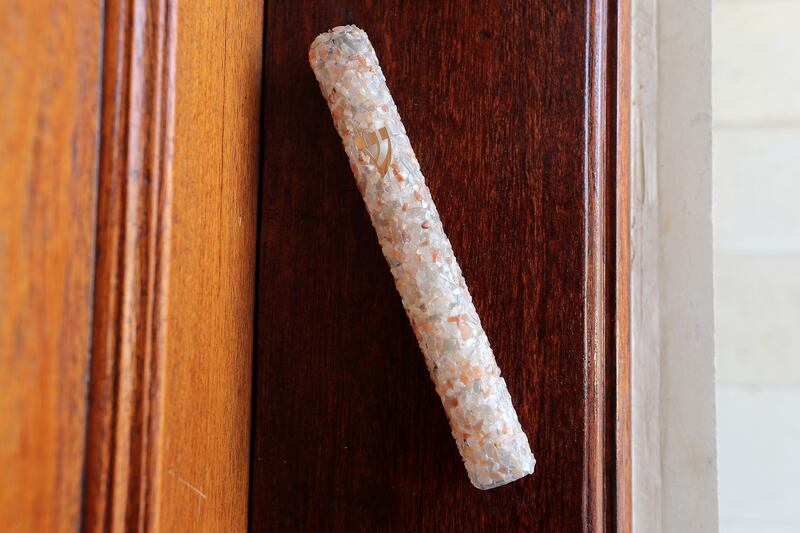 A mezuzah, which is a small, rolled parchment inscribed with scriptural verses to remind Jews of their obligations toward God.