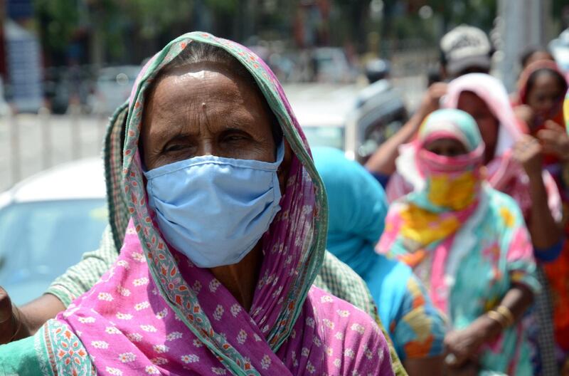 epa08397298 Indian people stand in a queue waiting to receive free food from the authorities during a nationwide lockdown in Guwahati, India, 02 May 2020. Indian ministry of home affairs (MHA) further extended the nationwide lockdown for another two weeks from May 03 to stem the widespread of the SARS-CoV-2 coronavirus.  EPA/STR