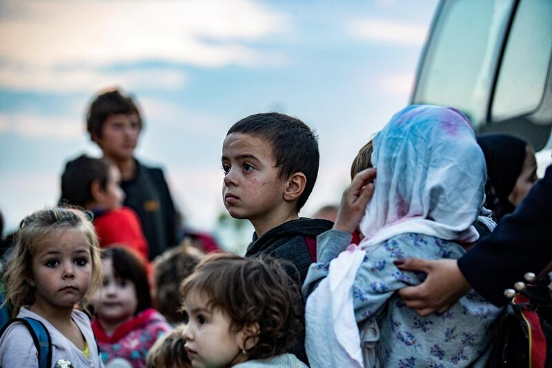 Russian children from the Kurdish-run al-Hol camp, which holds displaced families accused of being related to the Islamic State (IS) group, are handed over to a delegation from their country, in the northeastern Syrian city of Qamishli, on November 12, 2020. - A Kurdish foreign affairs official told AFP that 30 children and teenage girls between the ages of 2 and 14 were handed over to the Russian delegation. (Photo by Delil SOULEIMAN / AFP)