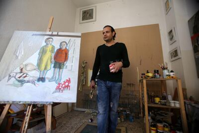 Iraqi refugee artist Saddam Al- Jumaily stands next to his paint with his sister at his home workshop in Amman, Jordan. (Salah Malkawi for The National)