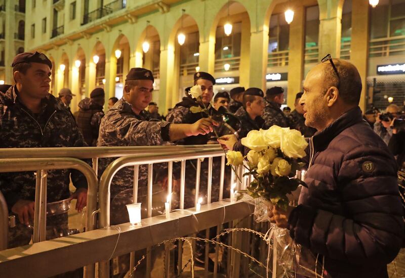 A Lebanese protester gives flowers to security forces during ongoing anti-government demonstrations in the capital Beirut. AFP