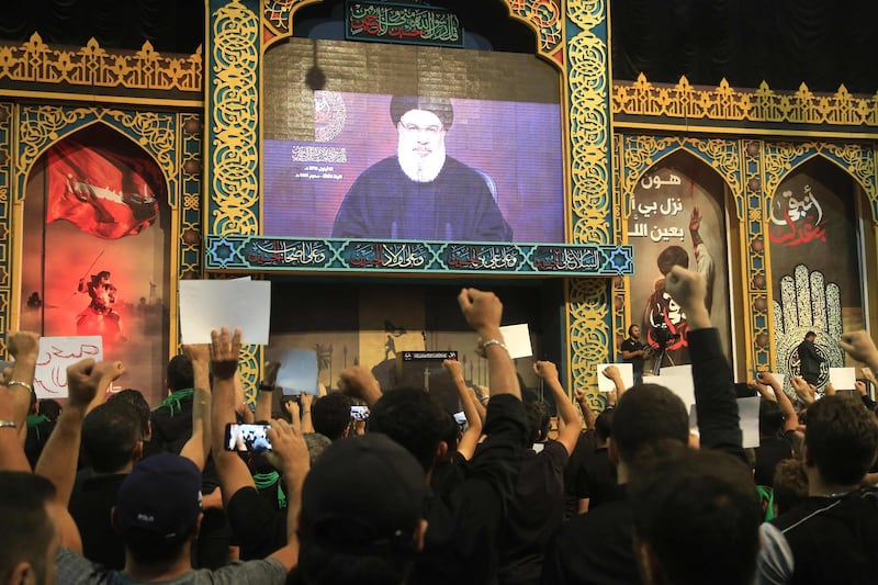 Supporters of the Lebanese Shiite Hezbollah movement react with clenched fists as they watch a speech by the movement's leader Hasan Nasrallah, transmitted on a large screen in the Lebanese capital Beirut's southern suburbs on September 2, 2019.  Nasrallah said today there were "no more red lines" in the Lebanese movement's confrontation with Israel, which flared in a cross-border exchange of fire a day earlier. 
 / AFP / ANWAR AMRO
