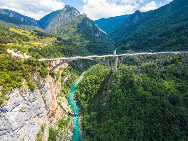 A bridge over the piercing blue River Tara which snakes between Montenegro and Bosnia and Herzegovina