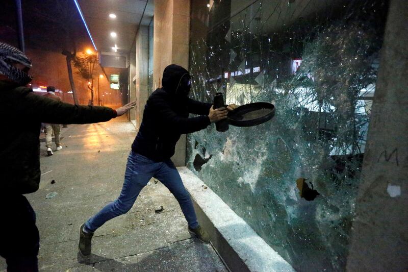 Protesters smash the window of a bank as demonstrations against the government continue in Beirut, Lebanon.  Reuters