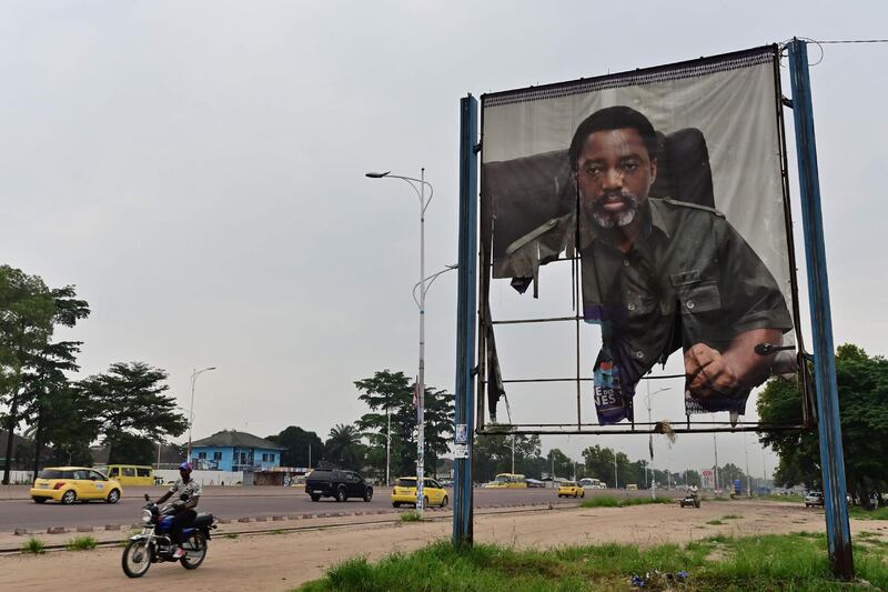 A man rides his motorcycle past a torned portrait of DR Congo's former president Joseph Kabila, on January 14, 2019, in the Nimite neighbourhood of the capital Kinshasa. Martin Fayulu, who came second in DR Congo's presidential election, has appealed to the Constitutional Court to annul the provisional result which awarded victory to his opposition rival Felix Tshisekedi, his lawyer said on January 12. Fayulu denounced the result as an "electoral coup" engineered by Kabila in which Tshisekedi was "totally complicit", saying the truth of what happened at the ballot box would only come out with a recount. / AFP / TONY KARUMBA
