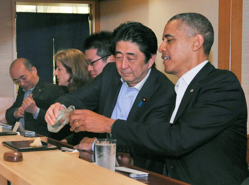Japanese Prime Minister Shinzo Abe  pours sake for US President Barack Obama as they have dinner at the Sukiyabashi Jiro sushi restaurant in Tokyo. Reuters