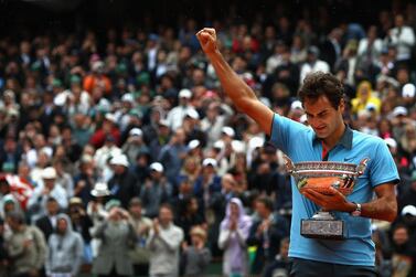 PARIS - JUNE 07: Roger Federer of Switzerland salutes the fans as he holds the trophy following victory during the Men's Singles Final match against Robin Soderling of Sweden on day fifteen of the French Open at Roland Garros on June 7, 2009 in Paris, France. (Photo by Ryan Pierse/Getty Images)