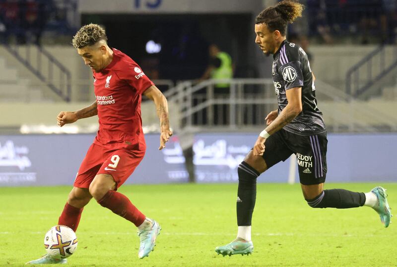 Lyon's French defender Malo Gusto challenges Liverpool's Brazilian striker Roberto Firmino. AFP