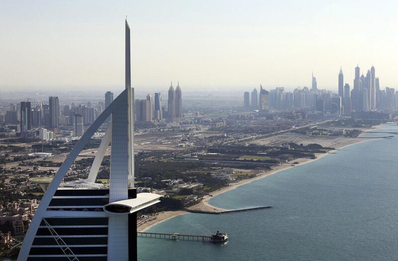 City skyscrapers stand near the coast beyond the tip of the Burj Al Arab luxury hotel, left, in Dubai. The seven-star hotel is a hot favourite among celebrities from around the world. Chris Ratcliffe / Bloomberg