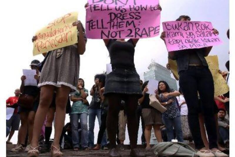 Women in Jakarta wearing miniskirts and tight leggings hold posters to protest against the idea that provocatively dressed women are to blame for sexual assaults. REUTERS / Stringer