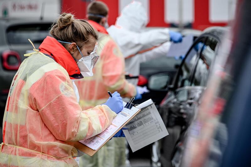 epa08305792 Paramedics of the German Red Cross collect swab samples from car drivers to be tested for coronavirus at a drive-thru testnig station in Oberhausen, western Germany, 19 March 2020. The German government and local authorities are heightening measures in a bid to stem the spread of the SARS-CoV-2 coronavirus, which causes the COVID-19 disease. According to the federal disease control agency, the Robert Koch Institute, the number of COVID-19 cases in Germany had exceeded the 12,000 mark by early 19 March 2020.  EPA/SASCHA STEINBACH