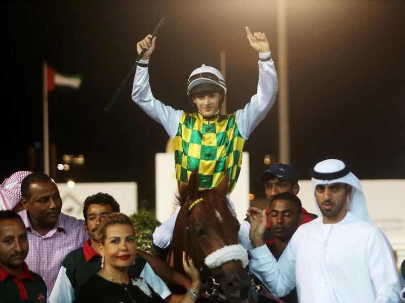 Harry Bentley, atop Thakif, celebrates after his National Day Cup win for trainer Majed Al Jahouri, right. Christopher Pike / The National

